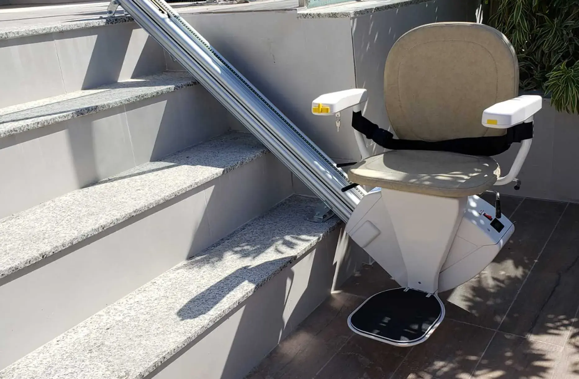 Freedom Stairlifts Outdoor Straight Stairlift in natural stone colour upholstery at the foot of four external steps