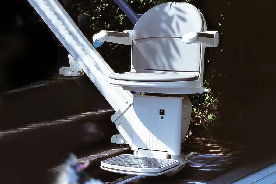 Close up view of a Freedom Stairlifts Outdoor Straight Stairlift in light coloured upholstery open at the foot of the stairs