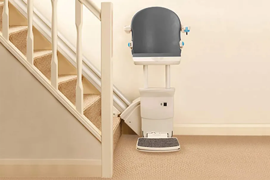 Freedom Stairlifts Straight Stairlift with a perched seat in slate coloured upholstery at the boottom of the stairs facing you